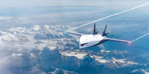 Un avion survole des montagnes enneigées, laissant derrière lui des traînées de condensation dans un ciel clair. Le nom "Nolinor" est visible sur l'appareil.